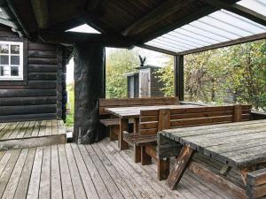 a wooden deck with benches and a table on a cabin at 6 person holiday home in Grenaa in Grenå