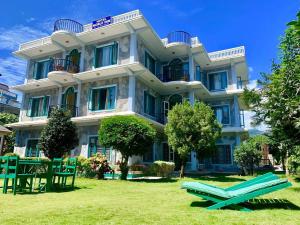 a large building with two lawn chairs in front of it at Hotel Noble Inn花椒客栈 in Pokhara