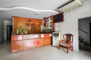 um restaurante com uma cadeira e uma televisão num quarto em OYO 89539 Hotel Siswa em Kampar