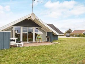 a house with a porch with a table and chairs at 5 person holiday home in Harbo re in Harboør