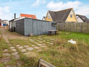 a backyard with a house and a bench next to a fence at 5 person holiday home in Thybor n in Thyborøn