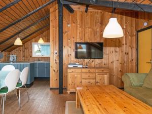 ein Wohnzimmer mit einem TV und einem Tisch in der Unterkunft 5 person holiday home in Harbo re in Harboør