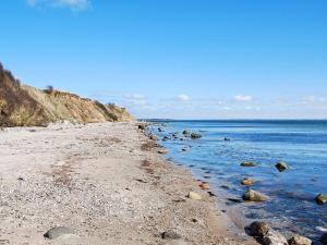 plaża z kamieniami i ocean w jasny dzień w obiekcie 6 person holiday home in Haderslev w mieście Årøsund