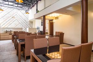 a restaurant with tables and chairs and a kitchen at RedDoorz near Alun Alun Bandung 2 in Bandung