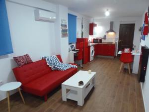 セビリアにあるApartamento en Trianaのリビングルーム(赤いソファ、テーブル付)