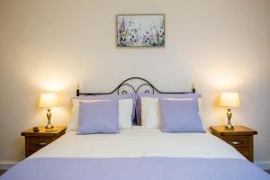1 dormitorio con 1 cama con almohadas azules y 2 lámparas en Awel Taf- Central cottage ideal for families, with parking en St Clears