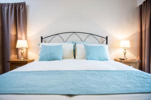 a bedroom with a blue and white bed with two lamps at Awel Taf- Central cottage ideal for families, with parking in St Clears +18 photos
