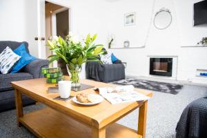 Sala de estar con mesa de centro y plato de comida en Awel Taf- Central cottage ideal for families, with parking en St Clears