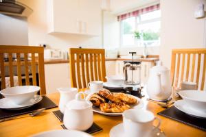 a wooden table with a plate of food on it at Awel Taf- Central cottage ideal for families, with parking in St Clears