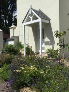 a garden with purple flowers in front of a white house at Park House in Budleigh Salterton