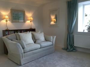 a living room with a white couch and a window at Park House in Budleigh Salterton