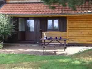 a picnic table in front of a wooden house at Large chalet with magnificent views in Dabo