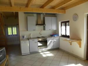 a kitchen with white appliances and a wooden ceiling at Large chalet with magnificent views in Dabo