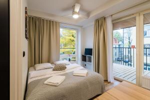 a bedroom with a large bed and a balcony at Thomas' Home - Trendy, Central & Balcony in Tallinn