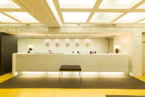 a lobby with a bench in front of a brow counter at Hotel il Grande Umeda in Osaka