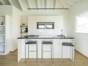 
a kitchen with white cabinets and white appliances at Beautiful Villa In Jan ThieL Near The Beach in Jan Thiel
