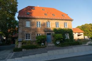 ein altes Backsteinhaus mit orangefarbenem Dach in der Unterkunft Kreuzstein Boutique-Apartment Hotel in Bayreuth