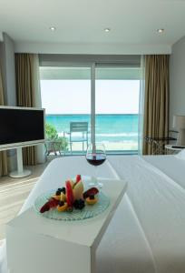 una copa de vino y fruta en una mesa en una habitación de hotel en Venn Boutique Hotel en Samsun