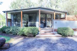 a small house with a porch and a garage at Karma Kinglake in Kings Lake East