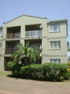 un bâtiment avec un palmier en face dans l'établissement North Beach Durban Apartments, à Durban