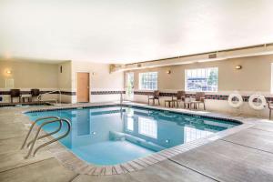 einen Pool in einem Hotel mit Stühlen und Tischen in der Unterkunft Comfort Suites Yakima in Yakima