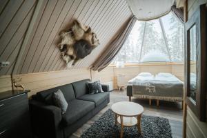a living room with a couch and a bed at Northern Lights Village in Saariselka
