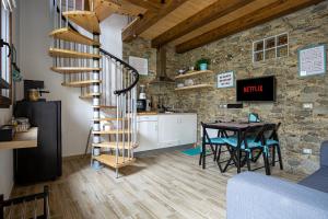 a kitchen and dining room with a spiral staircase and a table at Villa Margherita Ecolodge in Crespino