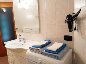 een badkamer met een wastafel, een spiegel en handdoeken bij Le Betulle in Vezzano