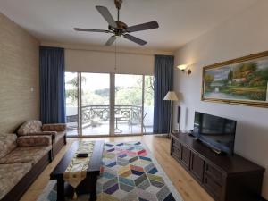 a living room with a couch and a tv at Little England B8 in Bukit Fraser