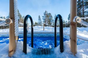 a swimming pool in the snow with ski poles at Northern Lights Village Saariselkä in Saariselka
