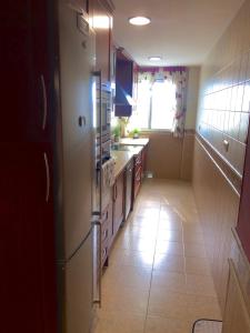 cocina con nevera y suelo de baldosa. en Piso semicentrico con vistas a la bahía de Algeciras en Algeciras