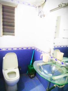 Beach Penthouse, Chennai في تشيناي: حمام ازرق مع مرحاض ومغسلة