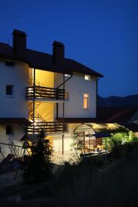 una casa con un edificio iluminado por la noche en Uyut Guest House, en Koktebel