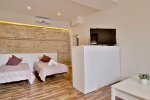 ein Wohnzimmer mit einem TV, einem Sofa und einem Stuhl in der Unterkunft La Quinta Hacienda in Córdoba