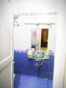 bagno blu con lavandino e specchio di Beach Penthouse, Chennai a Chennai