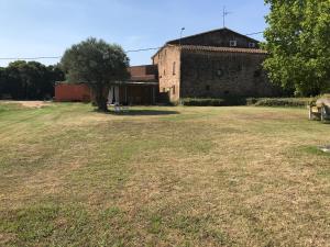 an empty field in front of an old building at La Caseta del Mas Valls in Rupiá