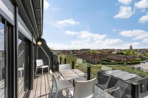 a balcony with a table and chairs and a view at Belcasa Family Suites & Lofts in Westende