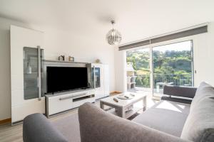 a living room with a large tv and a couch at Casa Leonardo in Arco da Calheta