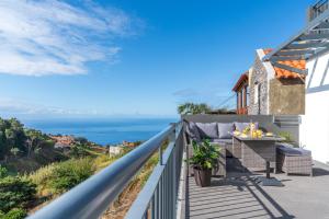 a balcony with a table and a view of the ocean at Casa Leonardo in Arco da Calheta