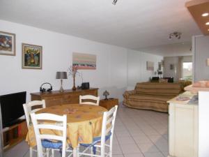 a living room with a table and a couch at Plage et jardin en centre ville in Saint-Raphaël