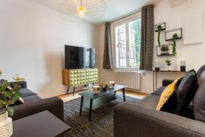 een woonkamer met 2 banken en een tv bij CMG Montmartre/ Marché Saint-Pierre in Parijs