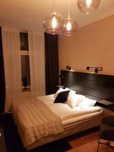 1 dormitorio con 1 cama grande y 2 luces en Hotell Kong Christian en Kristianstad