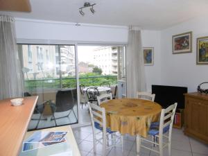 a dining room with a table and a balcony at Plage et jardin en centre ville in Saint-Raphaël
