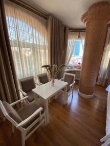 a dining room with a white table and chairs at The Red Bricks Hotel in Shkodër