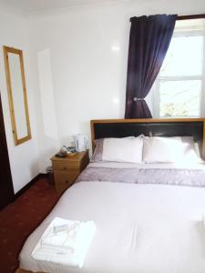 a bedroom with a large bed with a window at The Brown Trout Hotel in Watten