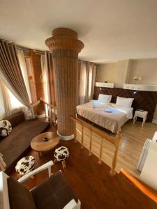 a large bedroom with a bed and a column at The Red Bricks Hotel in Shkodër