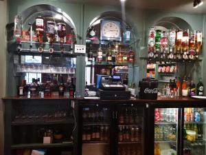 a bar with many bottles of alcohol and a clock at The Caledonian Thistle Hotel in Callander