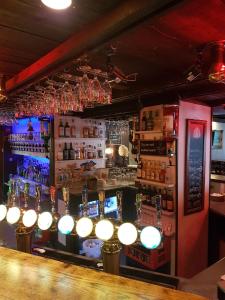 um bar com um balcão de bar com luzes por cima em Hotell Kong Christian em Kristianstad