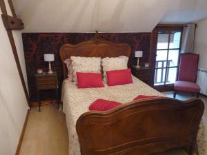 een slaapkamer met een groot bed met rode kussens bij L'arum antique in Sainte-Catherine-de-Fierbois