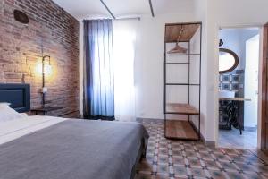 1 dormitorio con cama y pared de ladrillo en Carrara Bella en Carrara